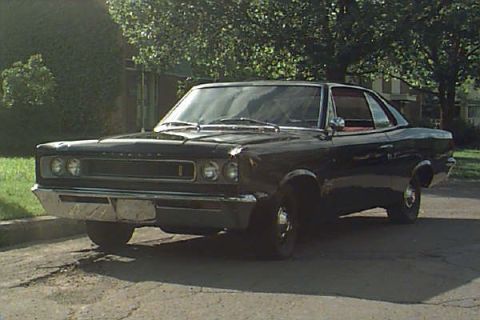 1993 Ford Taurus - This black coupe features a prominent chrome grille and bumper, indicative of a 1967 model year.