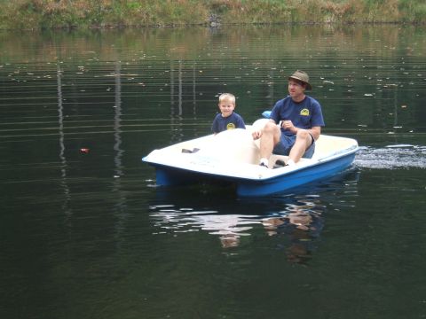 1995 Ford Bronco - A man and a child enjoy a ride on a pedal boat across a calm lake.