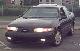 1993 Ford Taurus - A black 1992 Ford Taurus sedan is seen from the front-right angle, parked on a street.