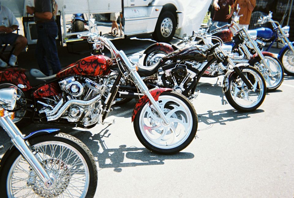 Row of custom chrome choppers parked in a lot at a bike show