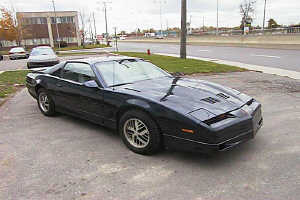 1993 Ford Taurus - 1985 Pontiac Firebird Trans Am with distinctive hood scoops and pop-up headlights.