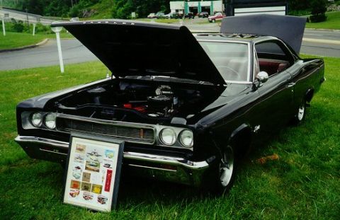 1993 Ford Taurus - A black 1968 AMC AMX coupe is displayed with its hood open on a grassy lawn.