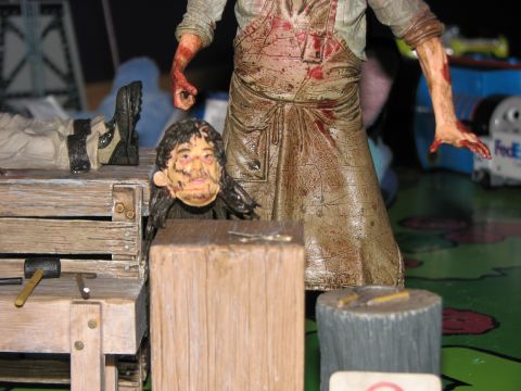 1991 Ford Bronco - A disturbing scene toy figures, one appearing to be a character from a horror movie, set up on a workbench.