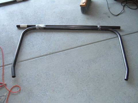 1993 Ford Bronco - This is a piece of bent metal tubing, possibly for a vehicle's roll cage, resting on a concrete floor.