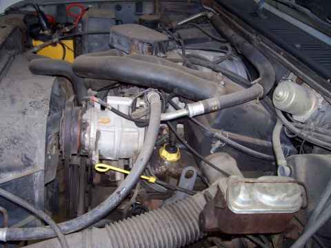 1985 Ford Bronco - Close-up view of a vehicle's engine compartment, showing various mechanical components.