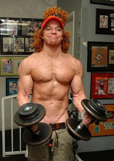 1991 Ford Bronco - A man with a distinctive hairstyle and beard poses with dumbbells in a gym setting.