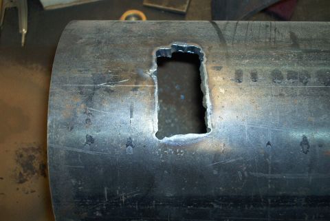 1983 Ford Bronco - A close-up view of a metal tube with a precisely cut rectangular opening, showing signs of fabrication.