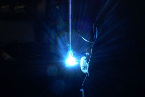 1983 Ford Bronco - A bright welding arc illuminates a dark scene, with the Supermotors.net logo visible in the corner.