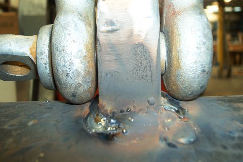 1983 Ford Bronco - Close-up view of a welded metal bracket and shackle connection, indicating heavy-duty use or modification.