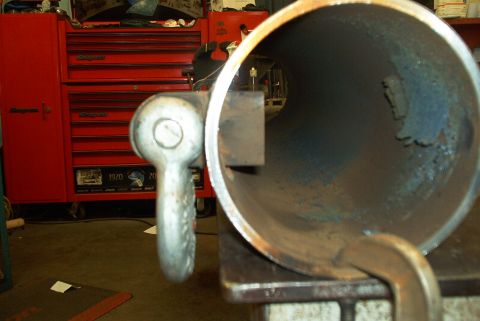 1983 Ford Bronco - A metal pipe with a tow hook is clamped to a surface, with a red tool chest visible behind it.