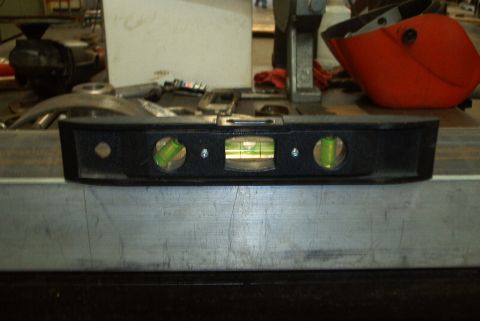 1983 Ford Bronco - A spirit level is shown in close-up, with a welding mask visible in the background.