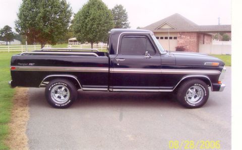2002 Ford Crown Victoria - This black Ford pickup truck has a Ranger XLT badge and chrome accents.