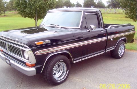 2002 Ford Crown Victoria - A black 1970 Ford F-Series pickup truck is shown from a three-quarter front angle.