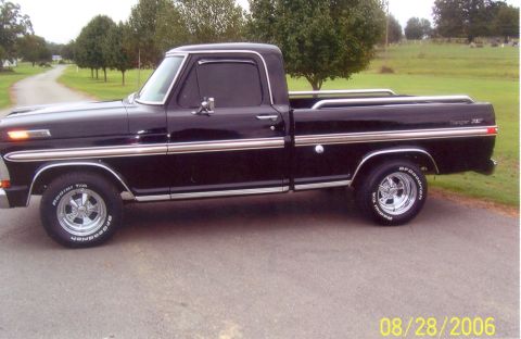 2002 Ford Crown Victoria - This black Ford pickup truck, likely from the 1970s, is shown from the side.