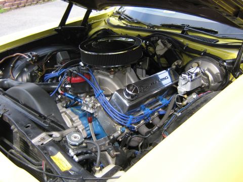 1978 Ford Ranchero - The engine bay of a yellow 1978 Ford Ranchero features Ford Racing valve covers and bright blue spark plug wires.