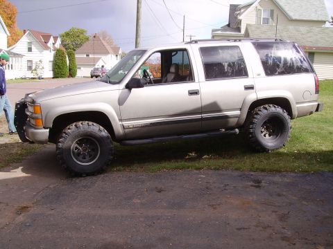 2000 Chevrolet Tahoe - This lifted Chevrolet Tahoe is parked on a grassy area next to a driveway.