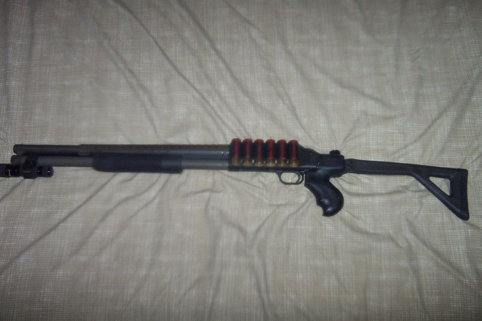 Shotgun with a tactical forend, pistol grip, and adjustable stock, loaded with red-shelled ammunition in a side saddle