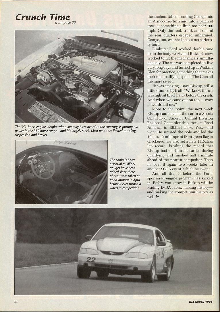 White 1995 Ford Mustang race car with number 22 on the door, seen from a 3/4 front angle on a track