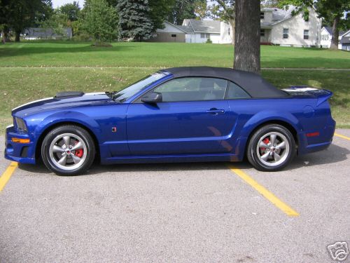 Blue Ford Mustang convertible parked in a lot with top up