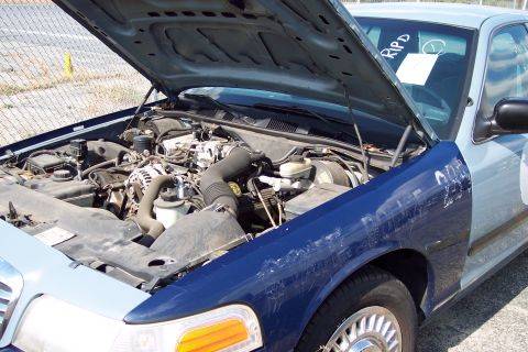 1991 Ford LTD Crown Victoria - Engine bay of a Ford Crown Victoria, showing the engine and surrounding components. Hood is open.