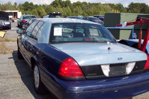 1991 Ford LTD Crown Victoria - A blue and silver Ford Crown Victoria is parked outdoors with other cars visible in the background.