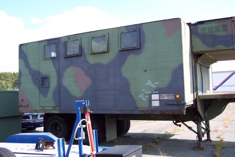 1991 Ford LTD Crown Victoria - A camouflaged military trailer is parked outdoors, with another vehicle visible in the background.