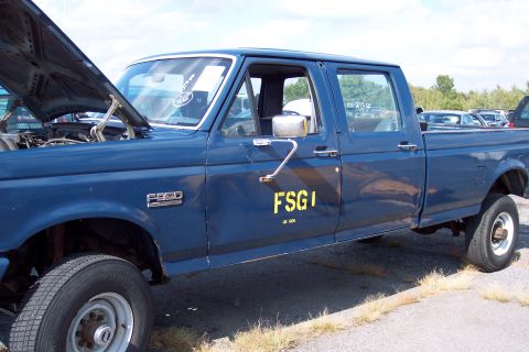 1991 Ford LTD Crown Victoria - A blue Ford F-350 truck is parked outdoors with its hood up, displaying government markings on the side.