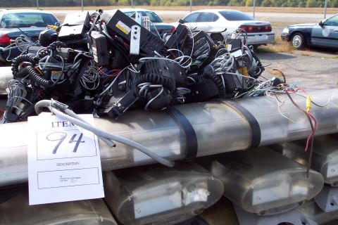 1991 Ford LTD Crown Victoria - A pallet of light bars and electronic equipment is piled up, with a tag indicating item number 94.