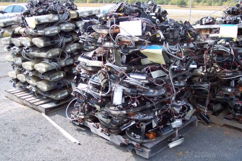 1991 Ford LTD Crown Victoria - A large quantity of automotive lighting components are piled up on pallets outdoors.