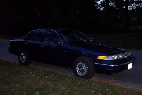 1991 Ford LTD Crown Victoria - A dark blue 1991 Ford Crown Victoria LTD is parked on the side of a road at dusk.