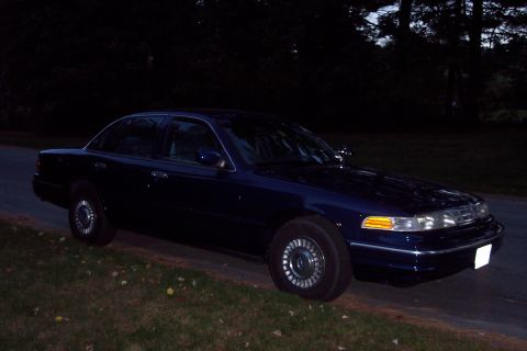 1991 Ford LTD Crown Victoria - Dark blue 1991 Ford Crown Victoria LTD parked on grass next to a road.