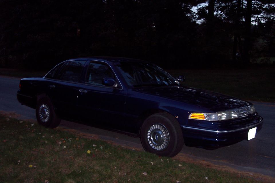1991 Ford Crown Victoria LTD parked on the side of a road at dusk