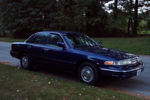 1991 Ford LTD Crown Victoria - This sedan has a distinctive grille and headlight design, suggesting a model year around 1992.