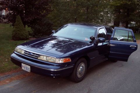 1991 Ford LTD Crown Victoria - This dark blue sedan, likely a 1992 model, has its front passenger and rear driver's side doors ajar.