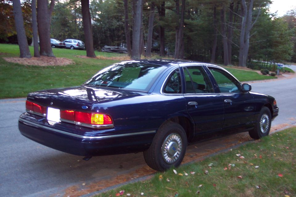 Dark blue sedan parked on a roadside, rear-left quarter view. Appears to be a 1992 model