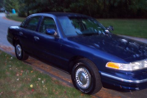 1991 Ford LTD Crown Victoria - Dark blue 1991 Ford Crown Victoria LTD parked on a roadside with trees in the background.