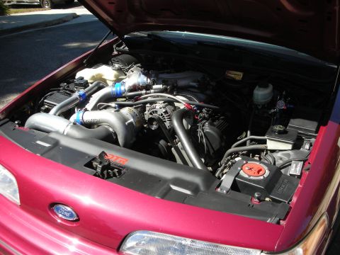 1992 Ford Crown Victoria - Open engine bay of a maroon Ford Crown Victoria showing a Paxton centrifugal supercharger with polished intake tubing, blue silicone couple…