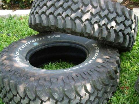 1979 Ford Bronco - BFGoodrich Mud-Terrain T/A tires are shown stacked on a grassy surface.
