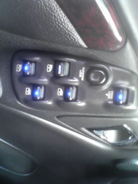 2000 Dodge Durango - Close-up of a car's interior door panel, highlighting the illuminated window controls.
