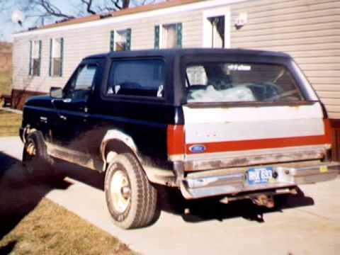 1989 Ford Bronco - This 1989 Ford Bronco is seen from the rear, a distinctive white stripe and the license plate RUX 693.
