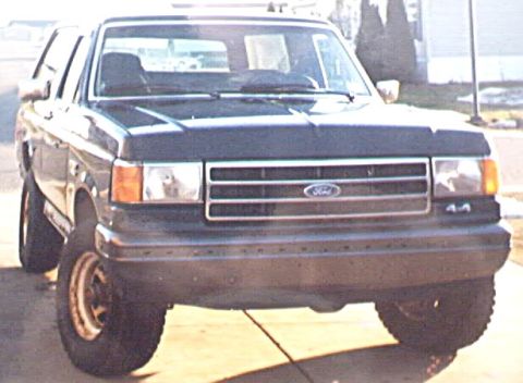 1989 Ford Bronco - Front view of a dark colored 1989 Ford Bronco parked outdoors.
