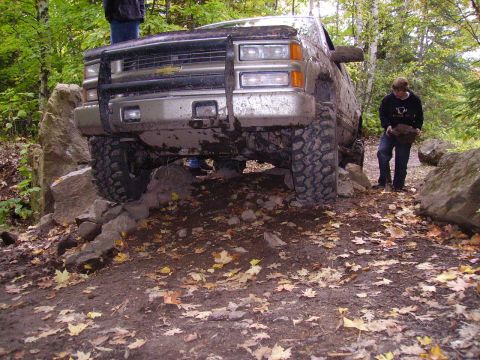 2000 Chevrolet Tahoe - This truck is navigating a challenging off-road course with large rocks and fallen leaves on the ground.