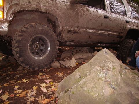 2000 Chevrolet Tahoe - 2000 Chevrolet Tahoe navigating a rocky off-road trail, covered in mud.