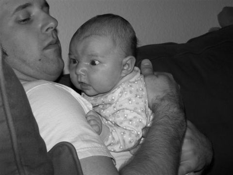 1995 Ford Bronco - A man holds a baby close, both looking in different directions in this black and white photograph.
