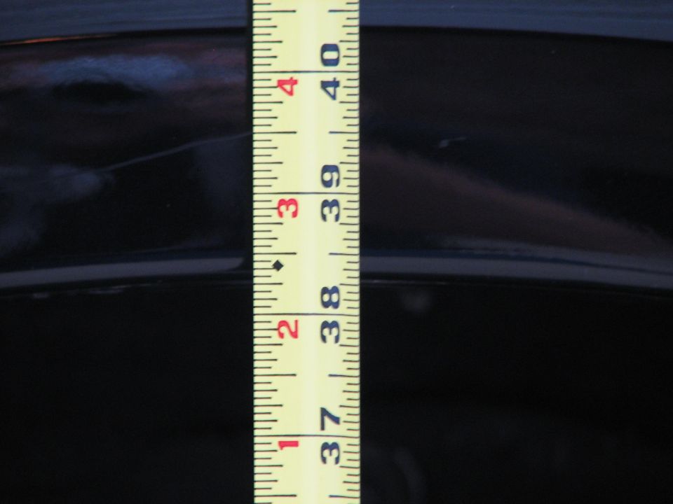 Tape measure against glossy black body panel reading 37 to 40 inches