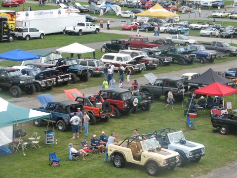 1992 Ford Bronco - A busy outdoor car show event with numerous vehicles and attendees gathered.
