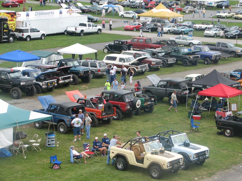 Overhead view of grass show field lined with early Broncos, lifted Ford trucks and canopies