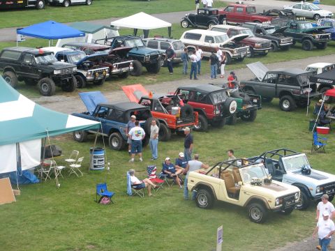 1992 Ford Bronco - Several Ford Broncos are gathered on a grassy field, possibly at a car show or meet.