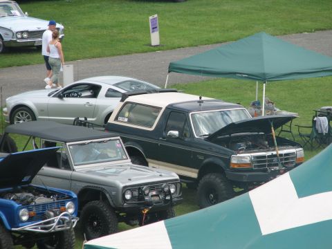 1992 Ford Bronco - A dark green 1992 Ford Bronco is displayed with its hood open at an outdoor car show.