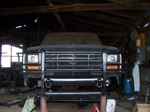 1983 Ford Bronco - This 1983 Ford Bronco is parked inside a workshop, showing its front grille and a heavy-duty brush guard.